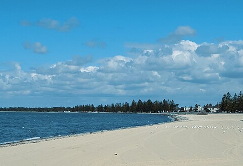 Altona sandy beach beside calm blue water